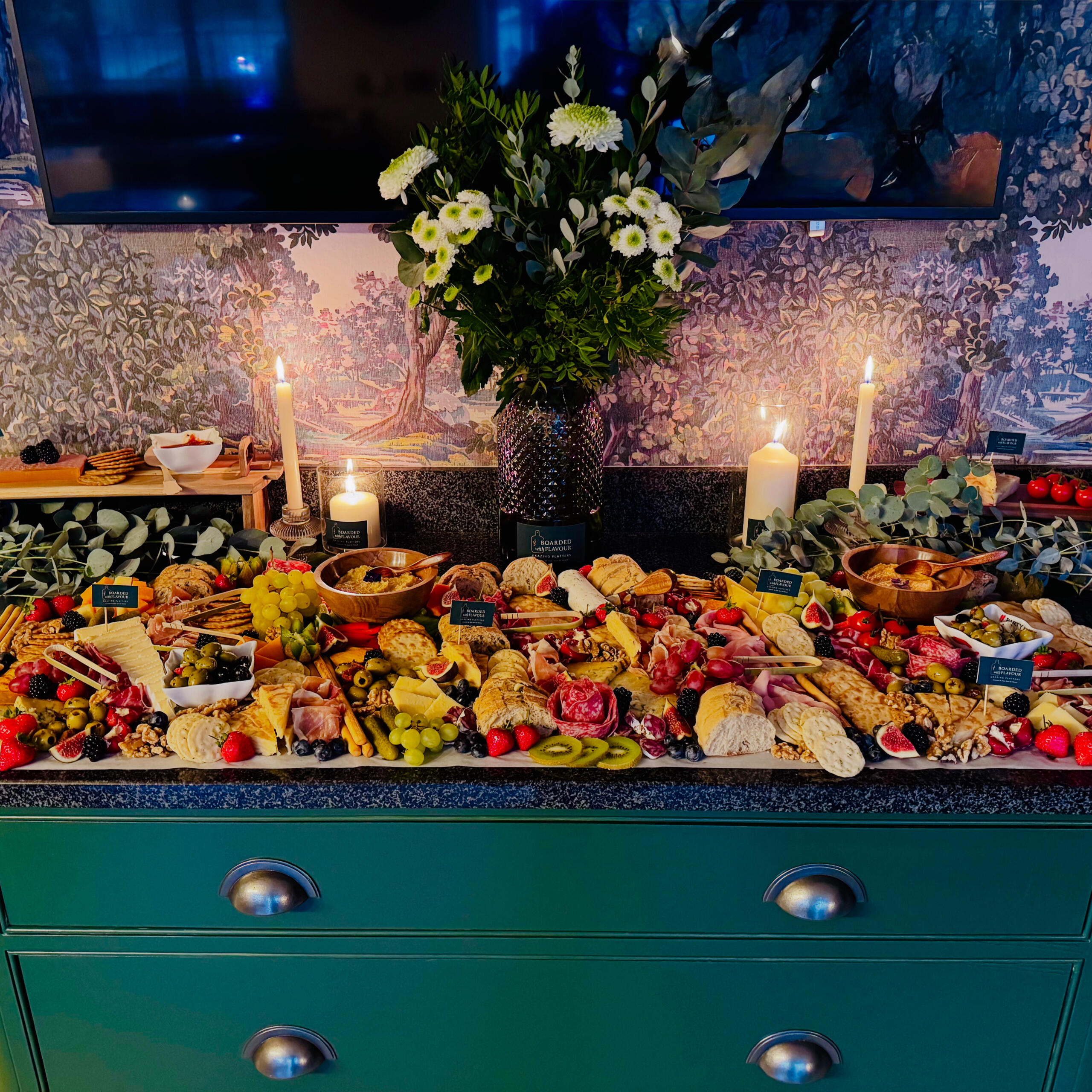 A close up of some charcuterie close up of some figs, cheeses, breadsticks, blueberries and nuts